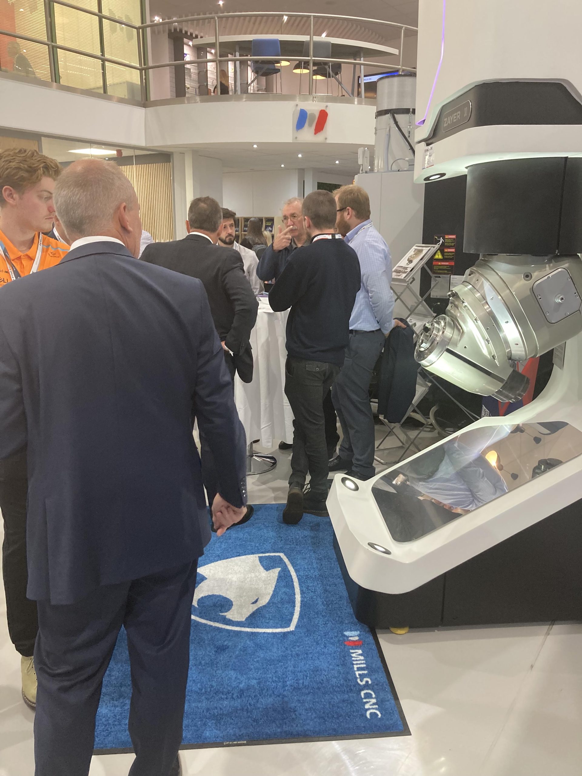 Visitors look at a Zayer machine display at the Mills CNC Open House